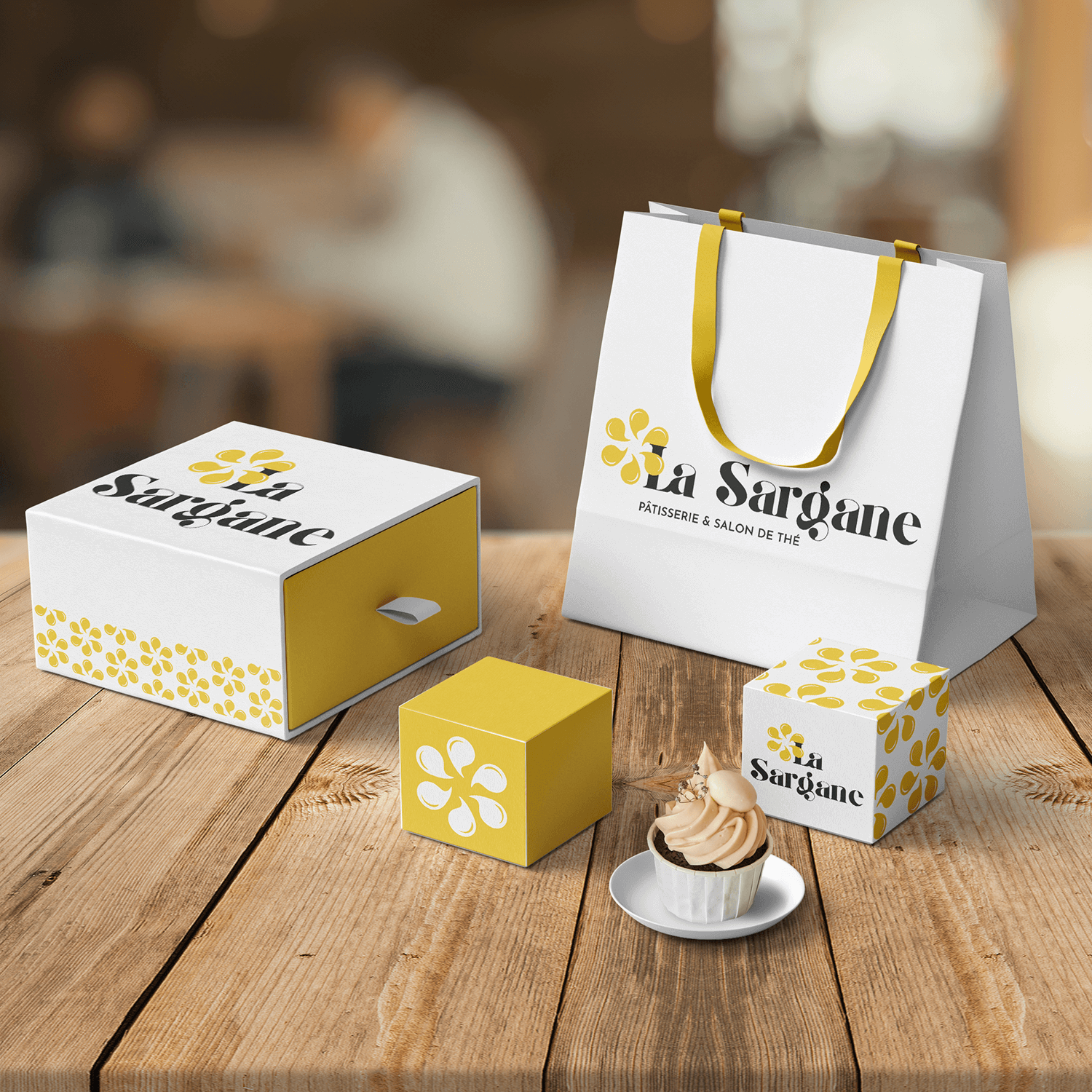 Mockup présentant des sacs de papier et boîtes de carton portant le logo de la Sargane